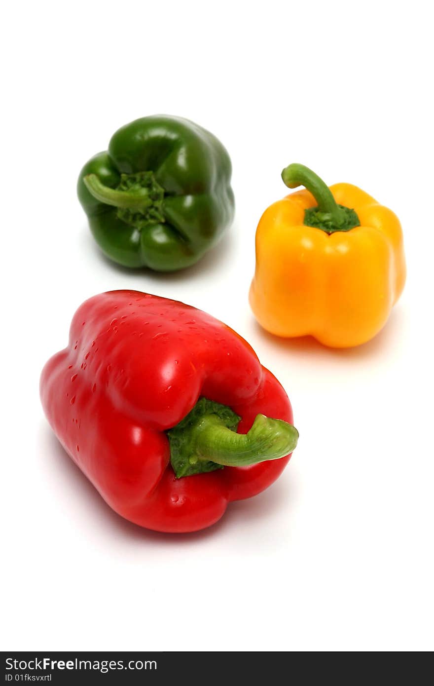 Red yellow and green peppers. Focus is on the red one.