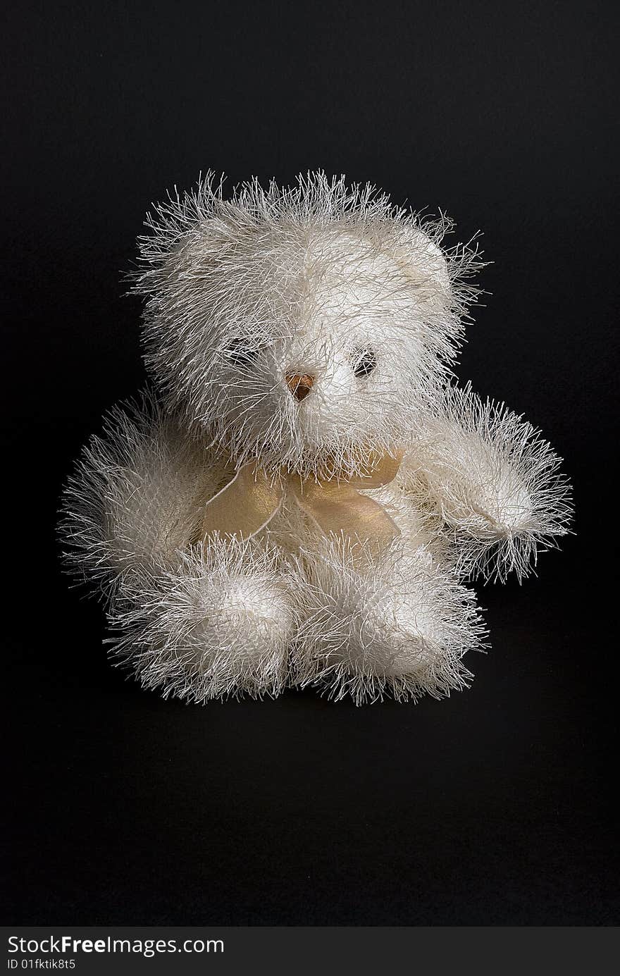 White downy bear toy isolated on a black background. White downy bear toy isolated on a black background