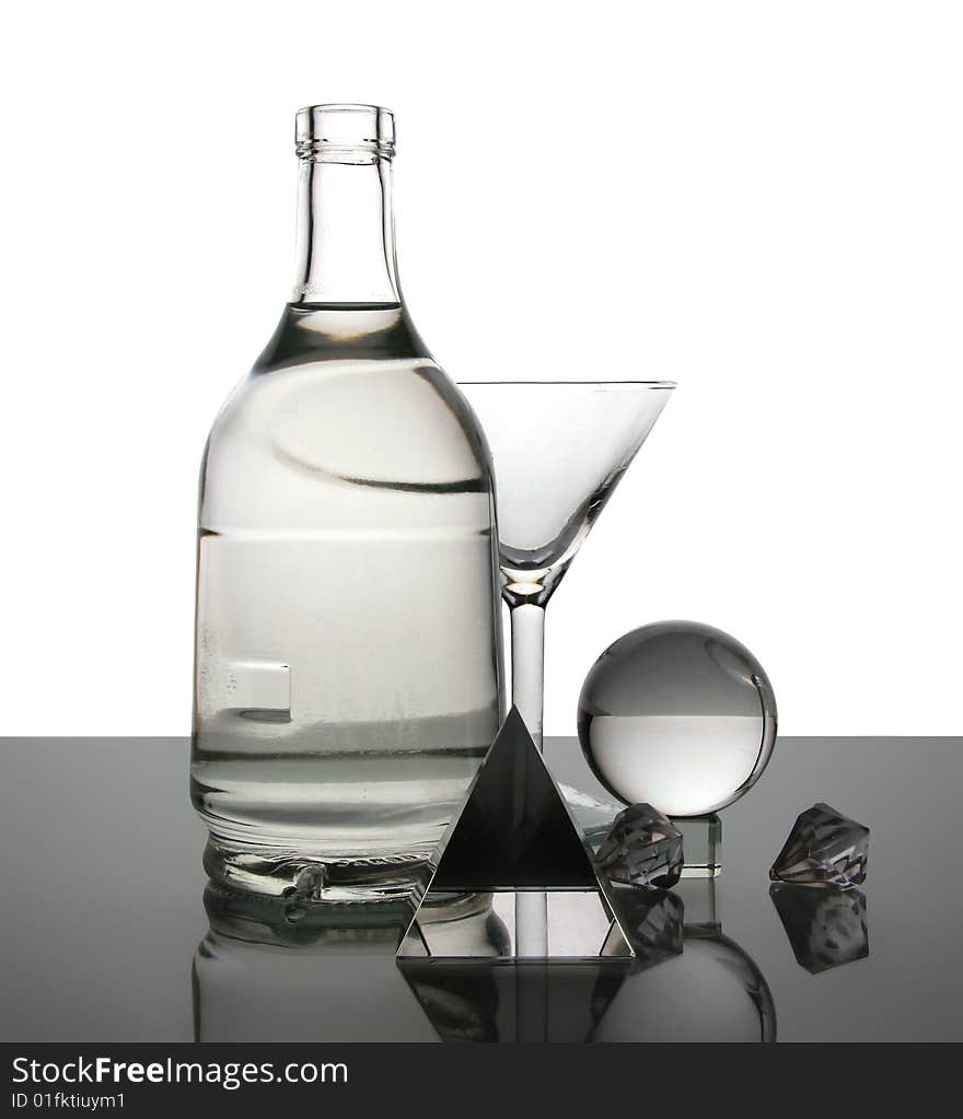 Still life with a glass and a bottle on a white background