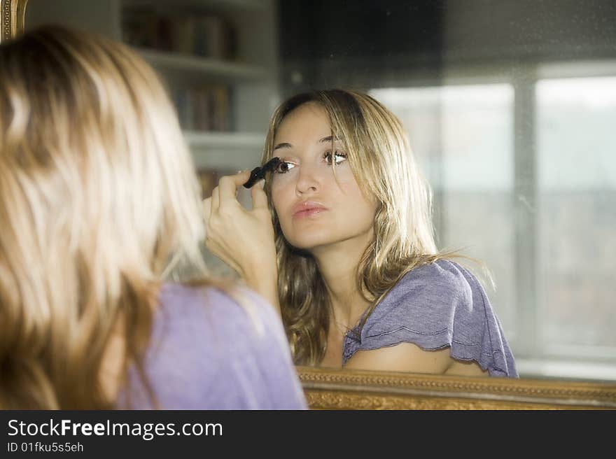 Woman applying makeup to her face