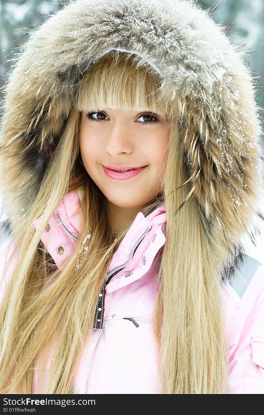 Portrait of a beautiful young woman with long blond hair having a walk in winter park. Portrait of a beautiful young woman with long blond hair having a walk in winter park