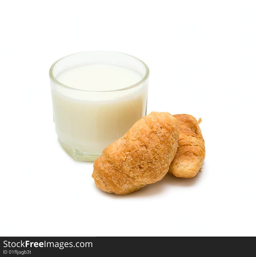 Glass with milk and cakes on plate isolated on white