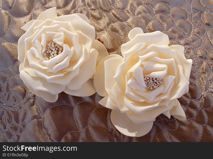 Imitation of roses in champagne color on brown background. Imitation of roses in champagne color on brown background