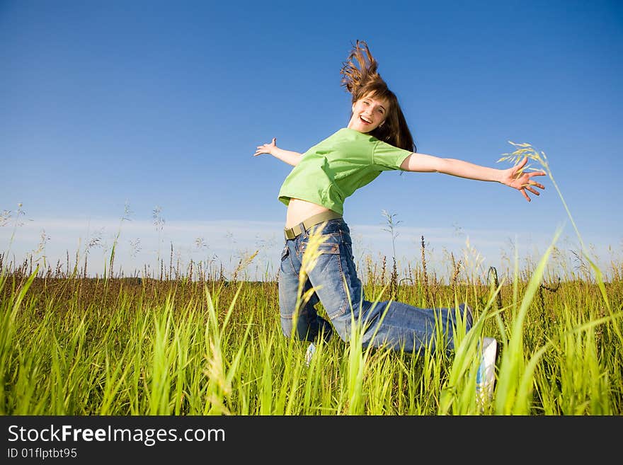 Happy jumping young woman. blue sky.