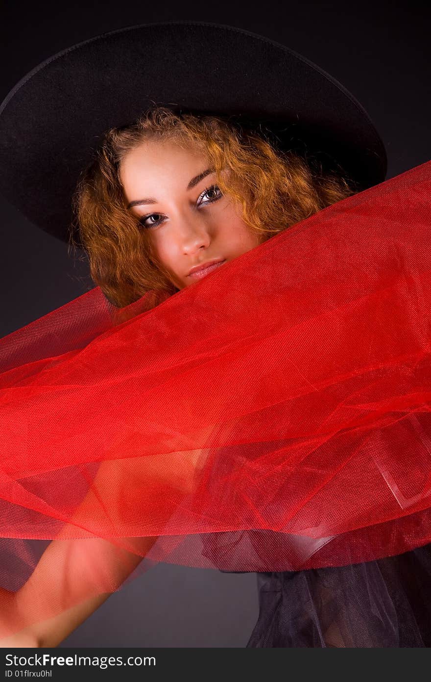 Attractive red-haired girl in hat, studio shot