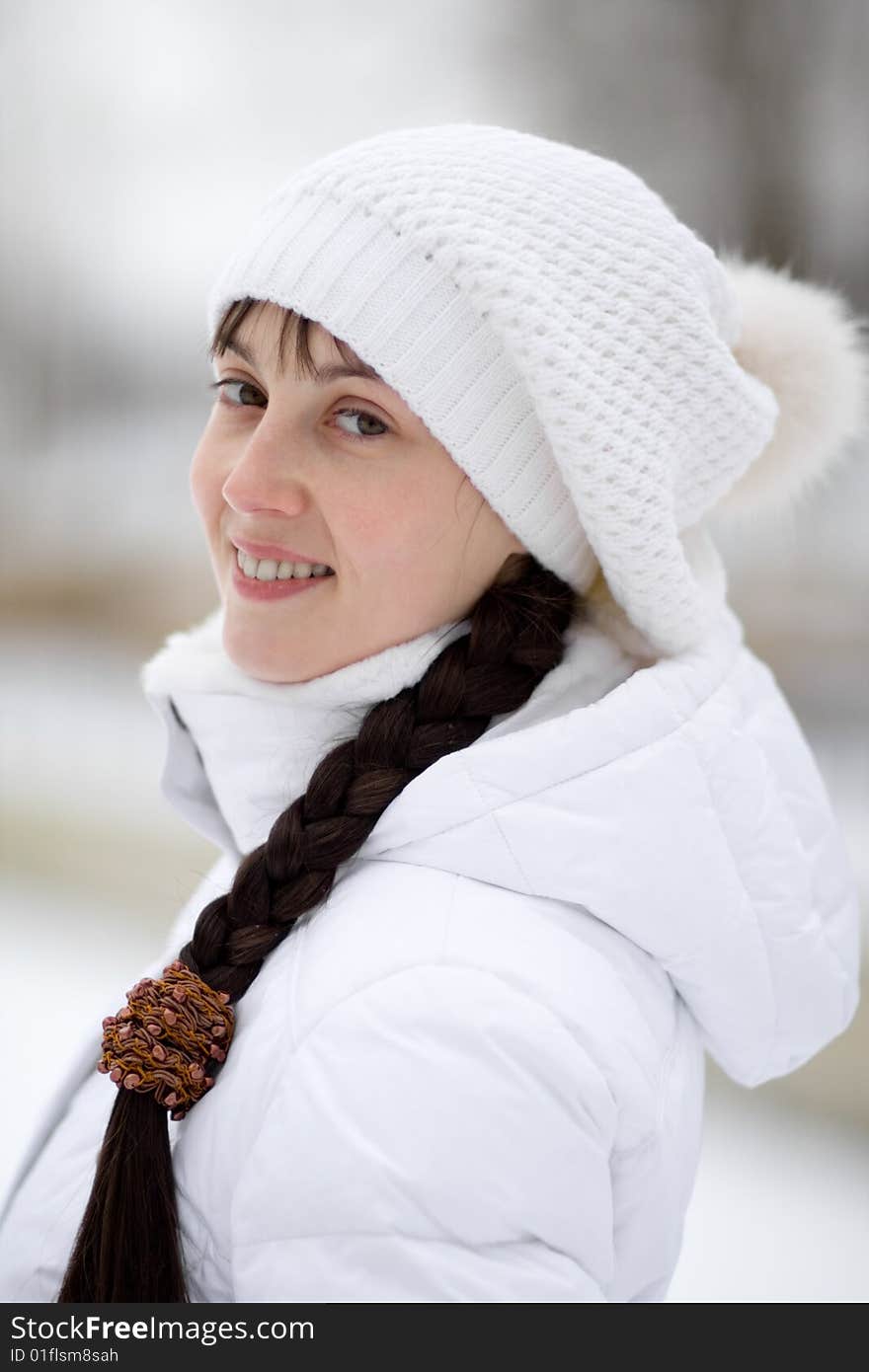 Smiling winter girl in white cap - shallow DOF