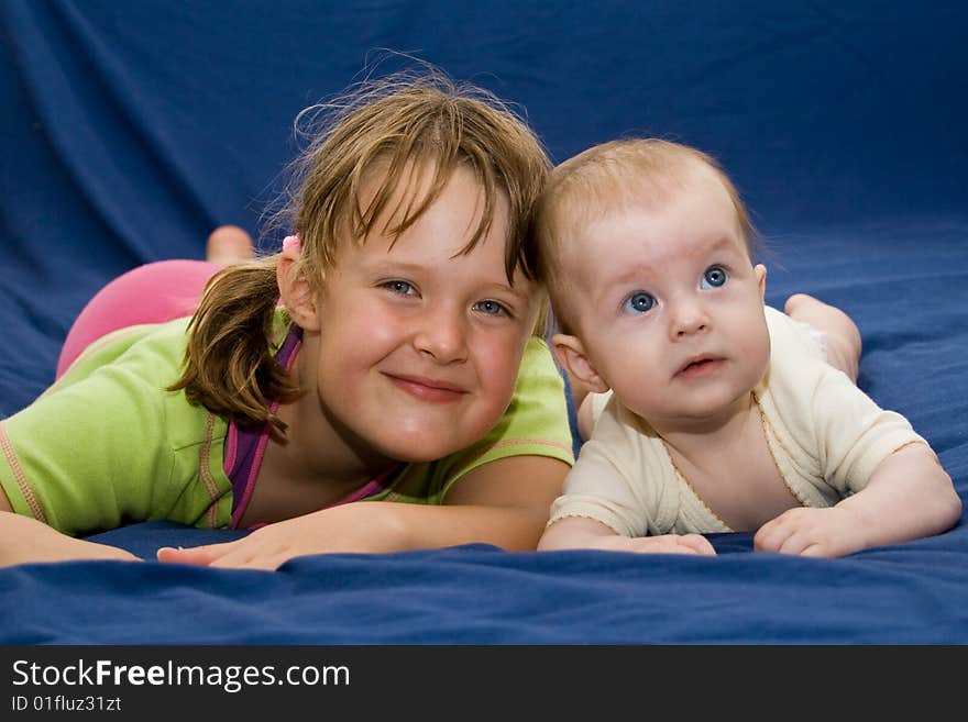 Kids laying on a blue bed. Kids laying on a blue bed