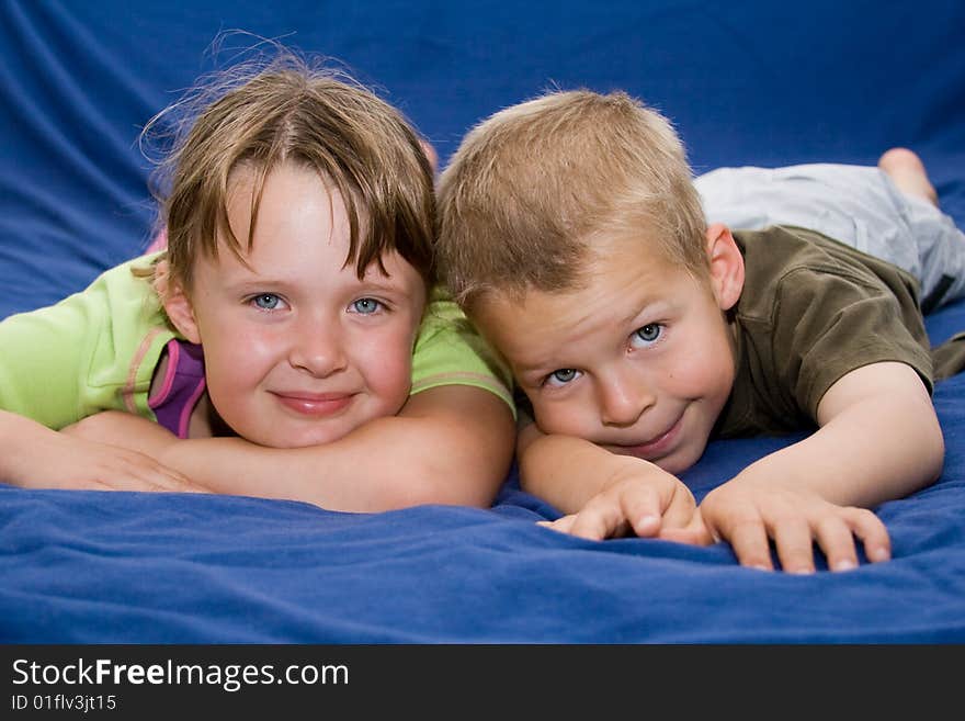 Kids laying on a blue bed. Kids laying on a blue bed