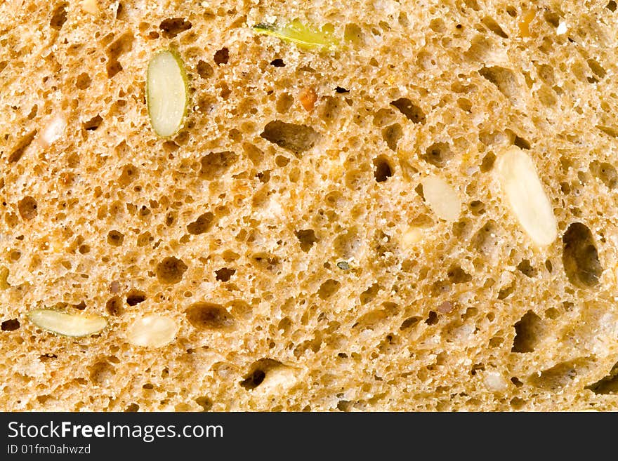 A close up of the texture of a slice of brown bread. A close up of the texture of a slice of brown bread