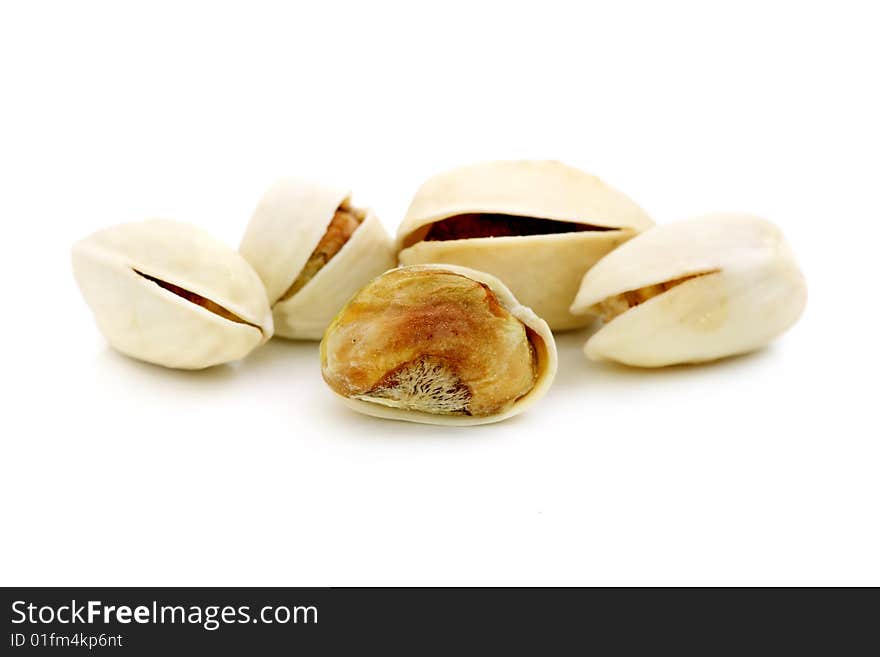 Pistachio nuts arranged in a row over white background.