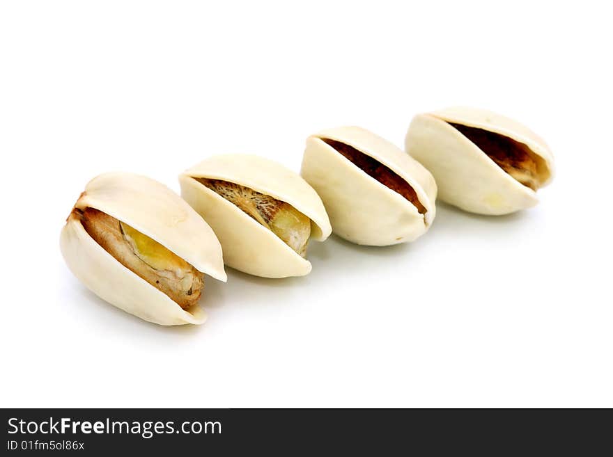 Four pistachio nuts arranged in a row over white background.