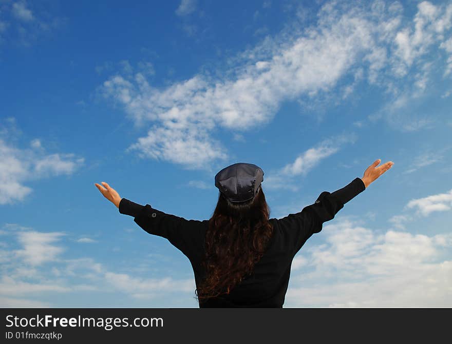 Young Woman Praying to the Sky by stretching her arms. Young Woman Praying to the Sky by stretching her arms