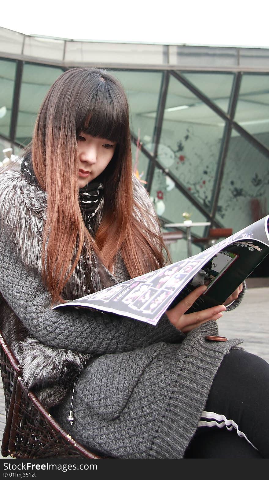 Beautiful asia woman is reading newspaper.