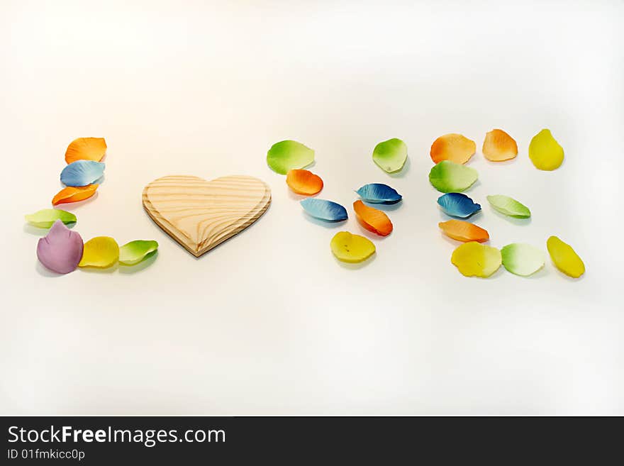 Word love with wood heart and flower petals