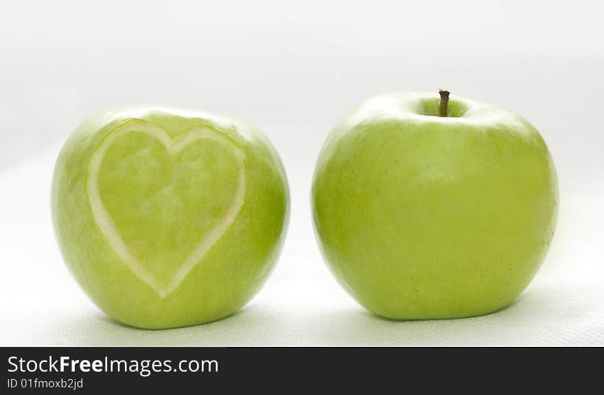 The image of two apples on which hearts are cut out. The image of two apples on which hearts are cut out