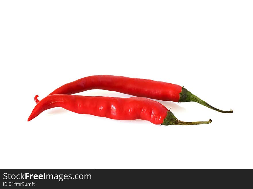 Two red hot chillis against a white background. Two red hot chillis against a white background