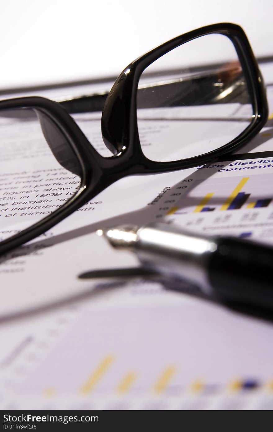 A Financial statement with a black frame eyeglasses and fountain pen.