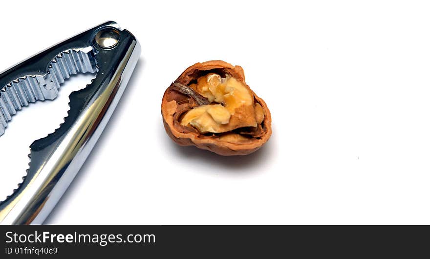 Photo of a nutcracker and an open walnut on a white background. Photo of a nutcracker and an open walnut on a white background