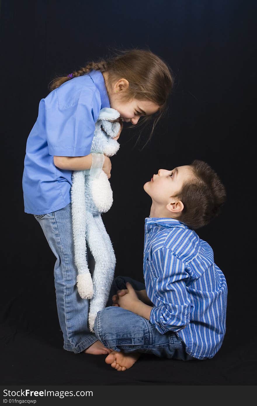 7 year old boy and his 5 year old sister playing on a black background. 7 year old boy and his 5 year old sister playing on a black background