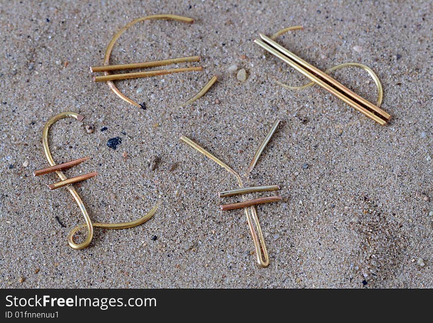 World money signs made from wire lying on sand background. World money signs made from wire lying on sand background