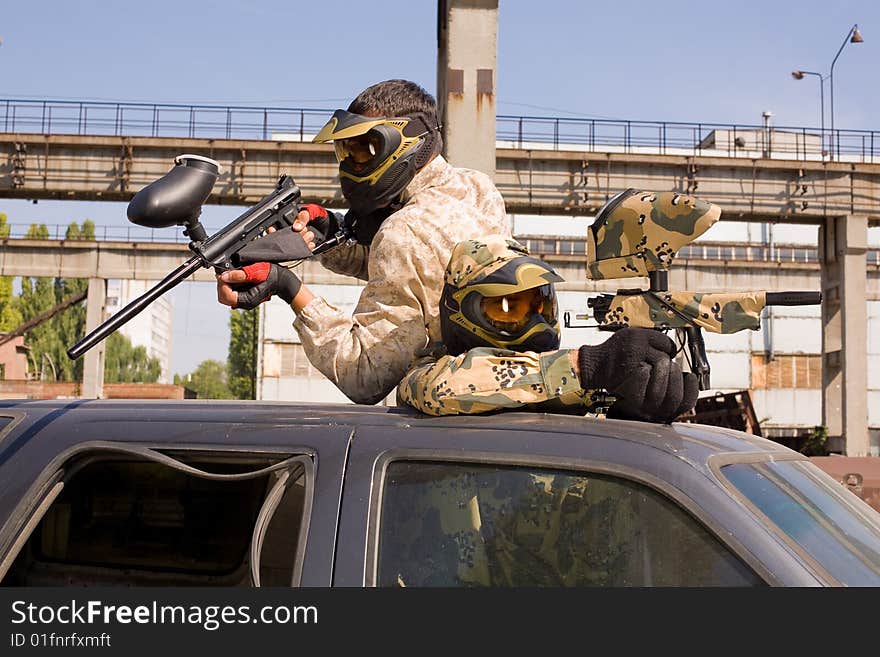 Two paintball players in abandoned places