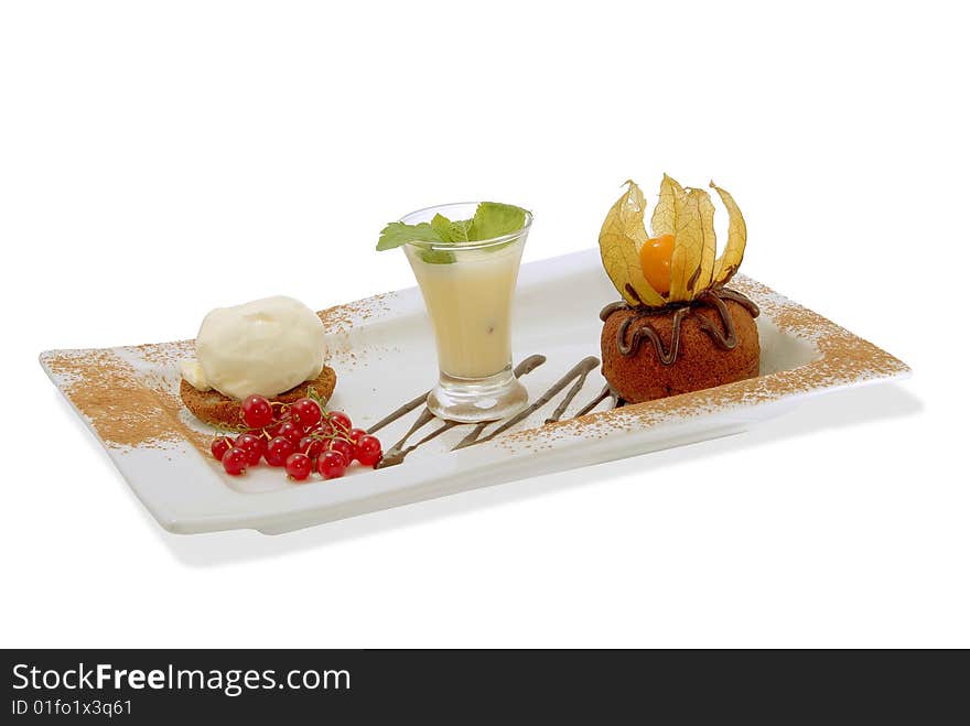 Chocolate cake on a decorated plate with vanilla ice cream, sauce and red currant. Isolated. Chocolate cake on a decorated plate with vanilla ice cream, sauce and red currant. Isolated.