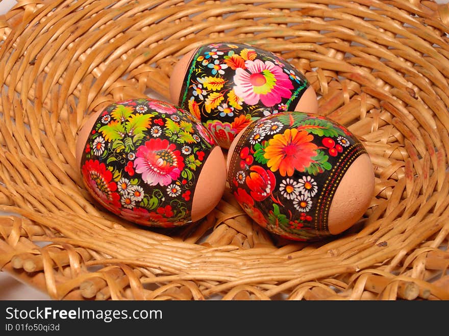 Three easter eggs are in a willow small basket