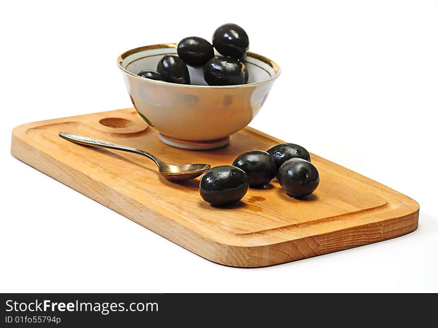 Olive in white cup on wooden plate