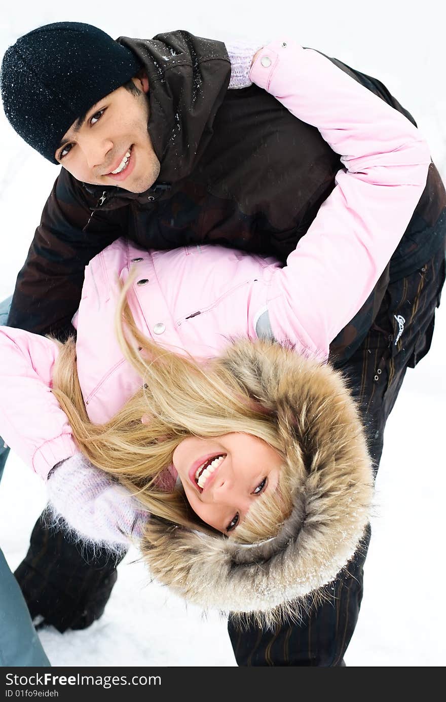 Happy young beautiful couple having fun in winter park. Happy young beautiful couple having fun in winter park