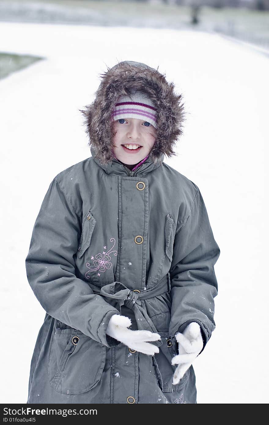 Mischievous girl wearing gloves in the snow