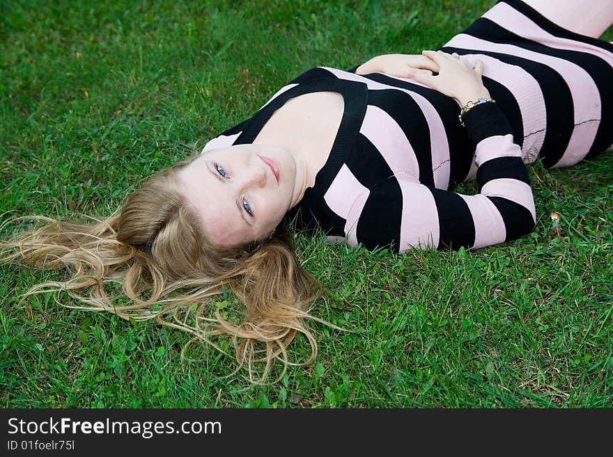 Beautiful girl lying on green grass