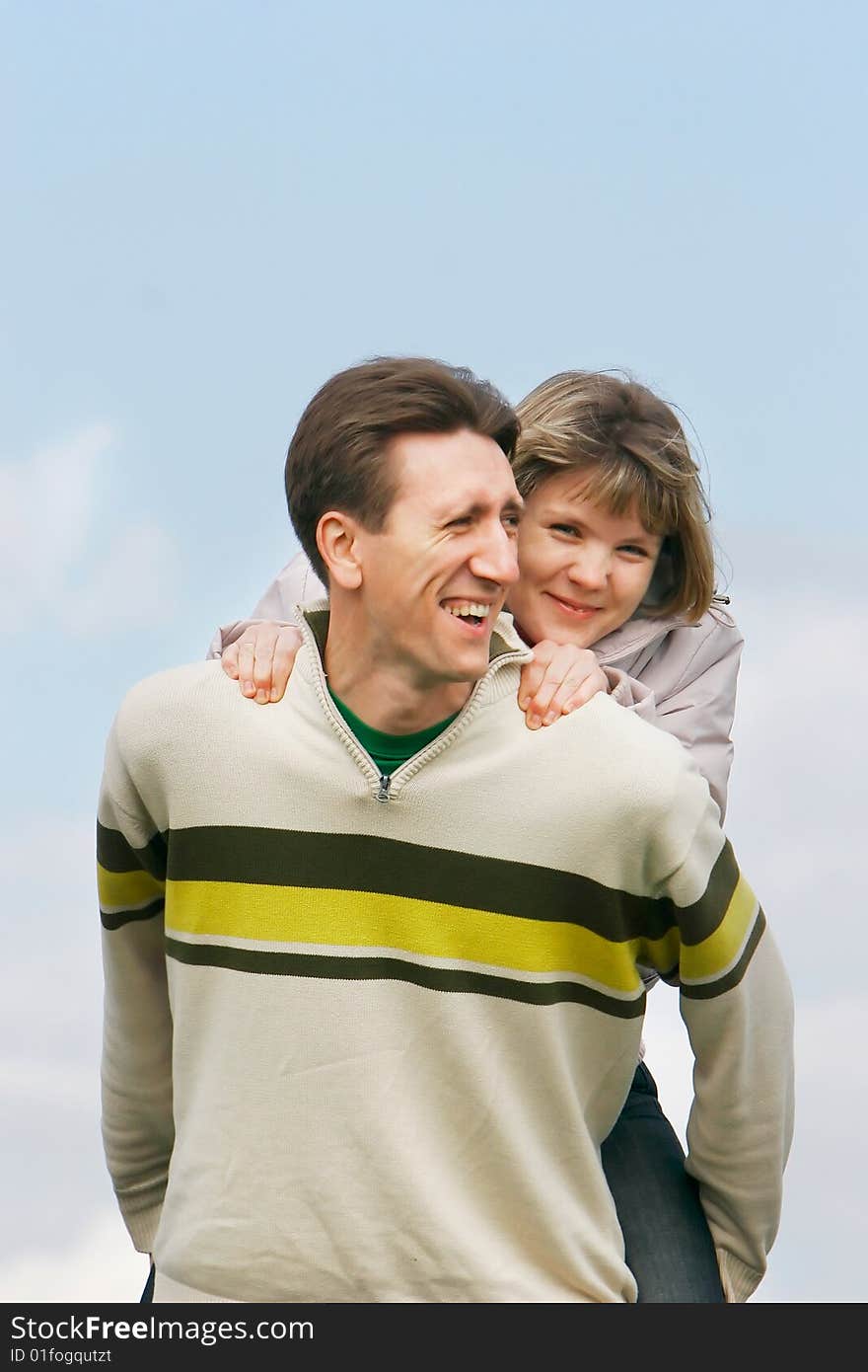 Young happy couple on sky background