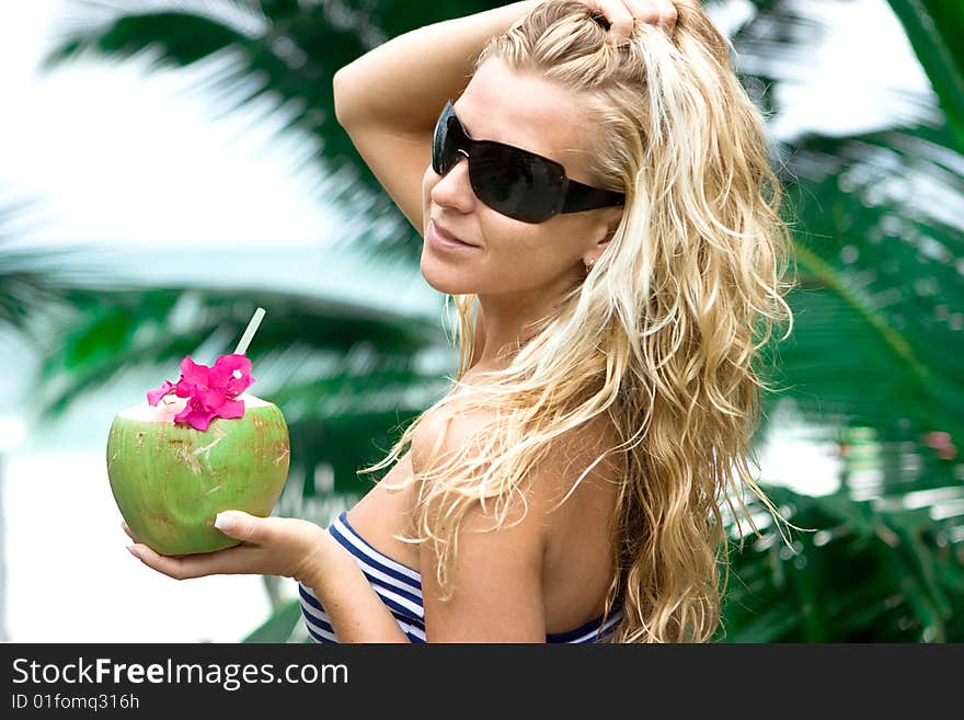 Girl holding coconut and palm on the background. Girl holding coconut and palm on the background