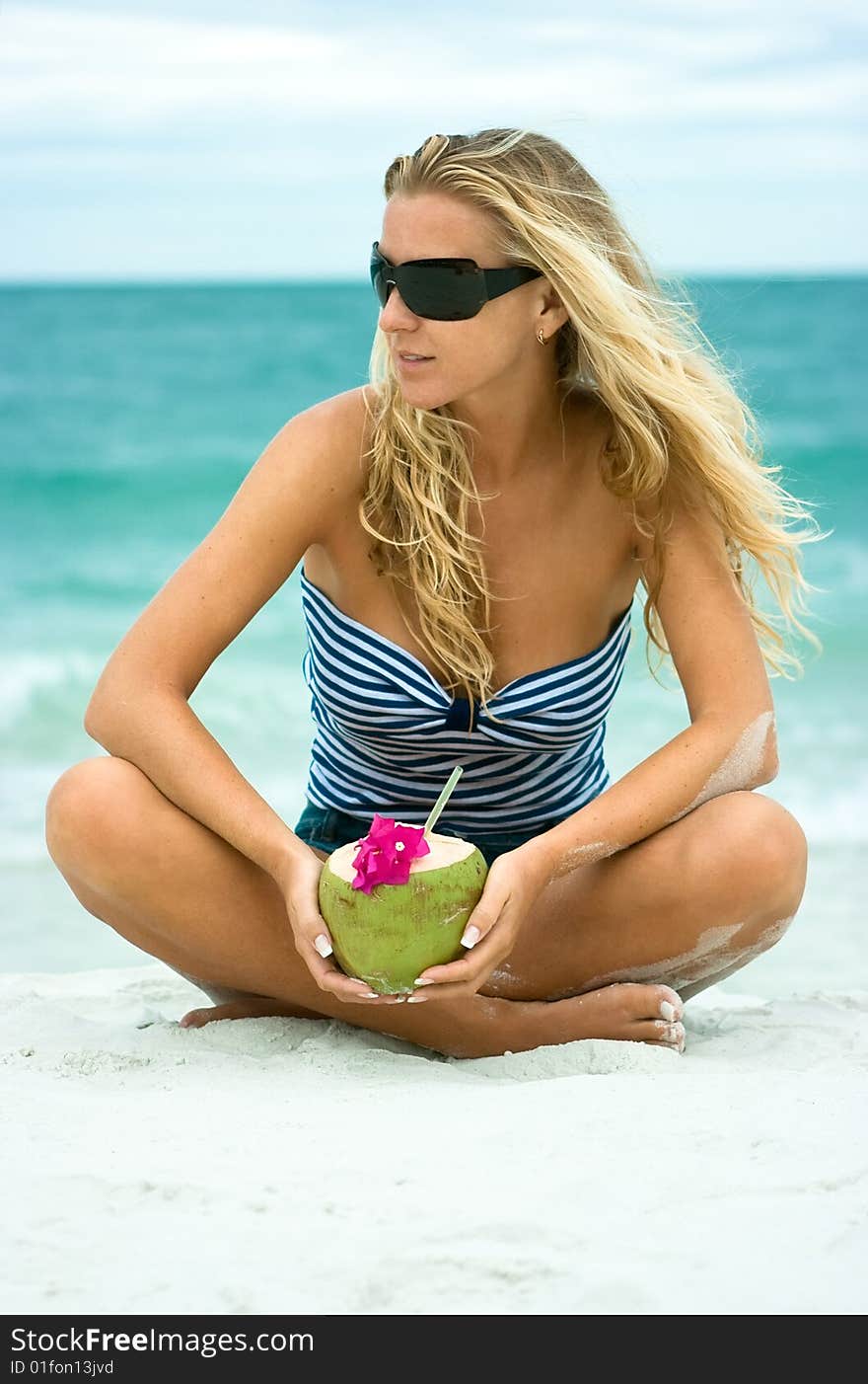 Cute girl with coconut sitting on the sand. Cute girl with coconut sitting on the sand