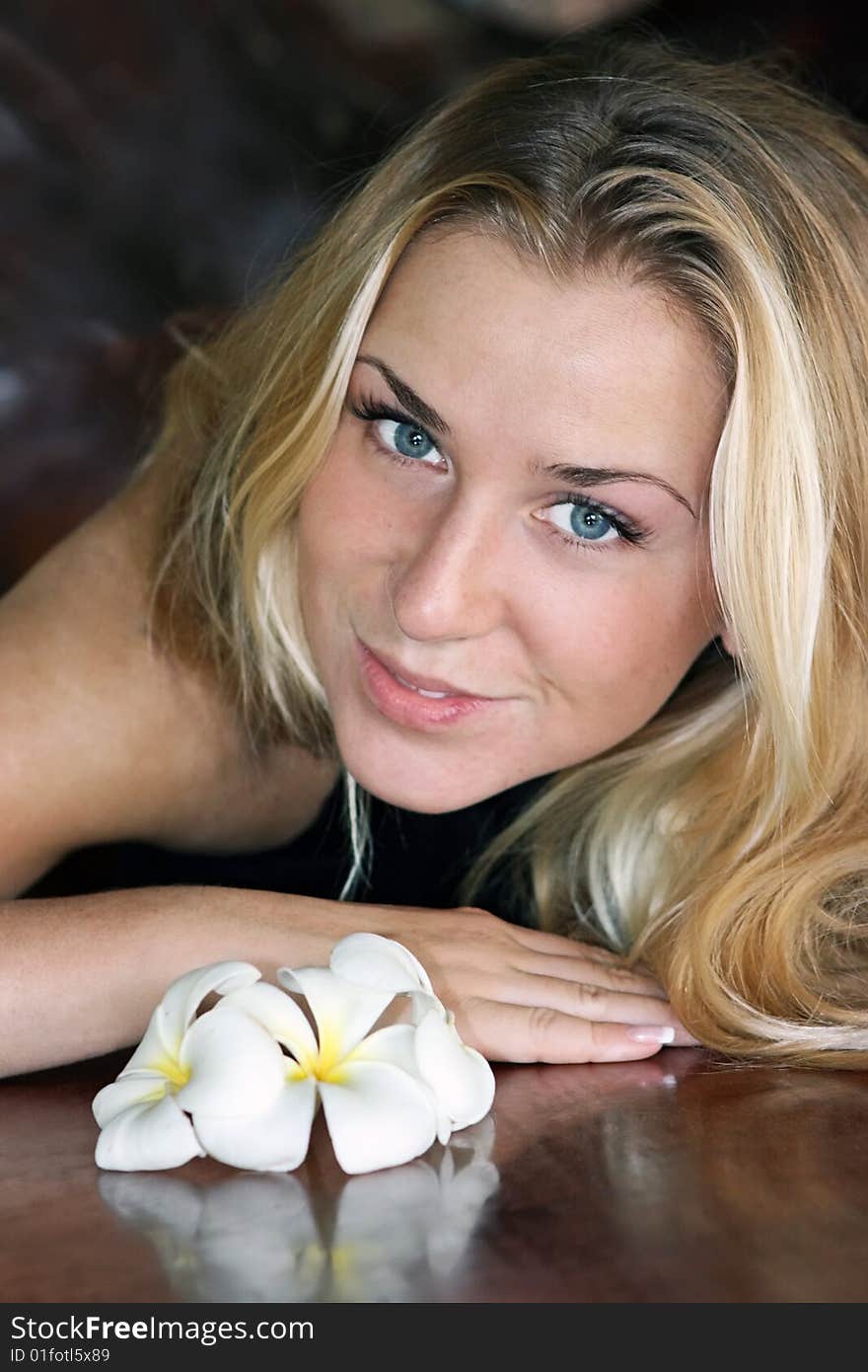 Cute girl sitting at the table with flowers on it. Cute girl sitting at the table with flowers on it