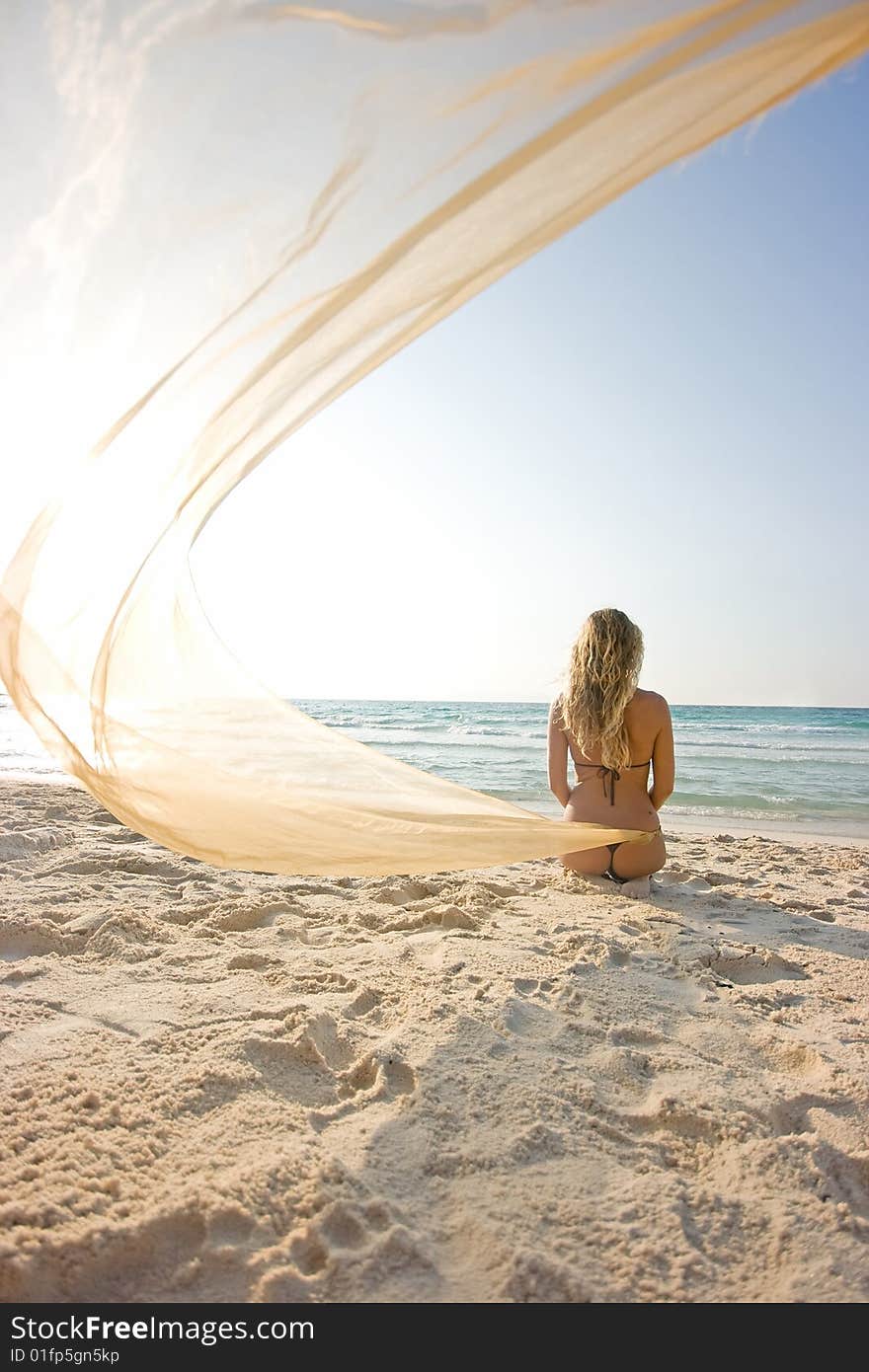 Blonde girl on the beach with shawl