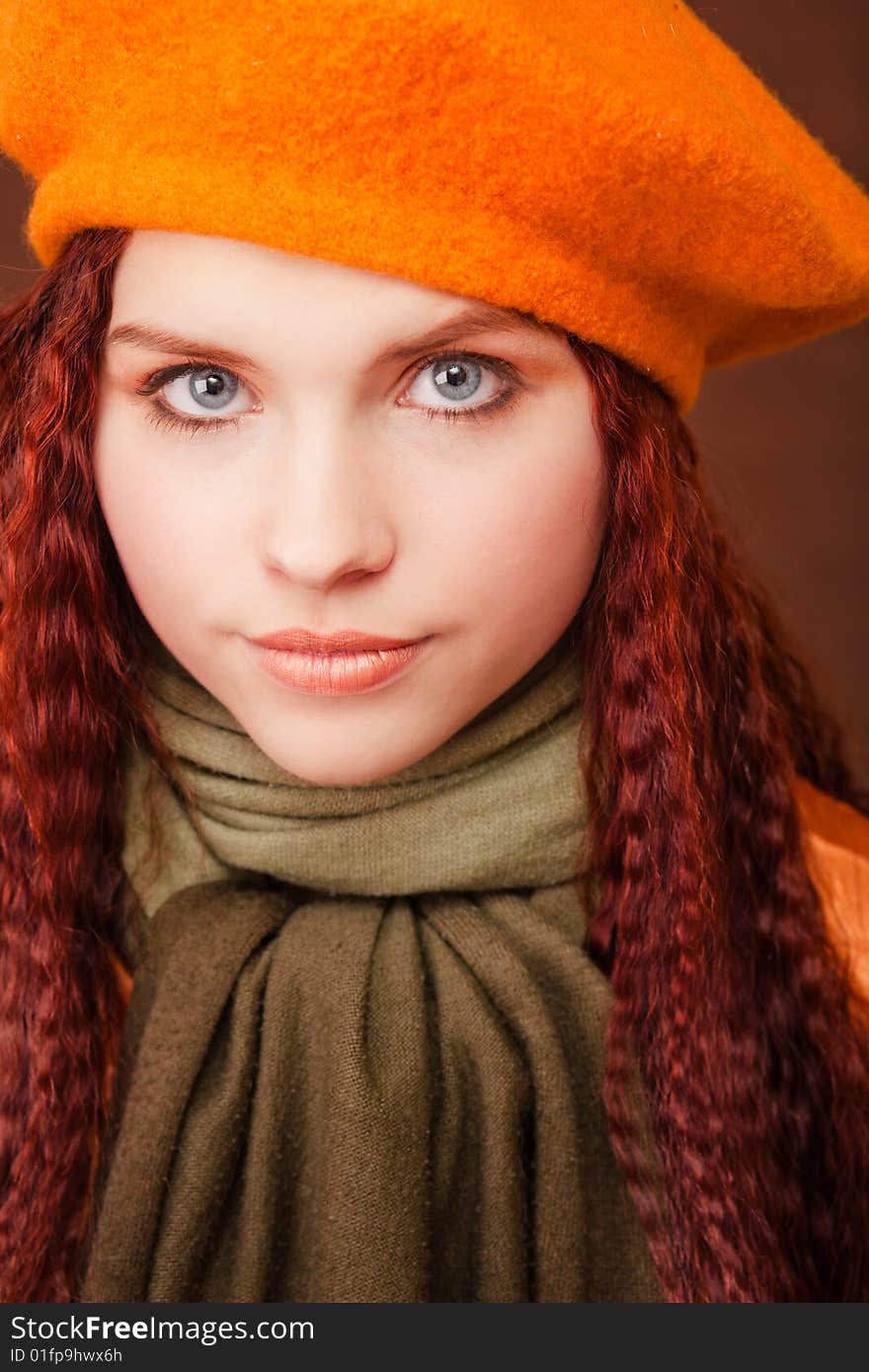 Young beautiful girl in orange beret on dark background. Young beautiful girl in orange beret on dark background