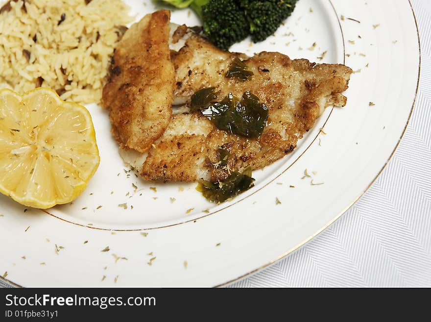 Fish meal with selective focus and wine bootle and glass in the background. Fish meal with selective focus and wine bootle and glass in the background