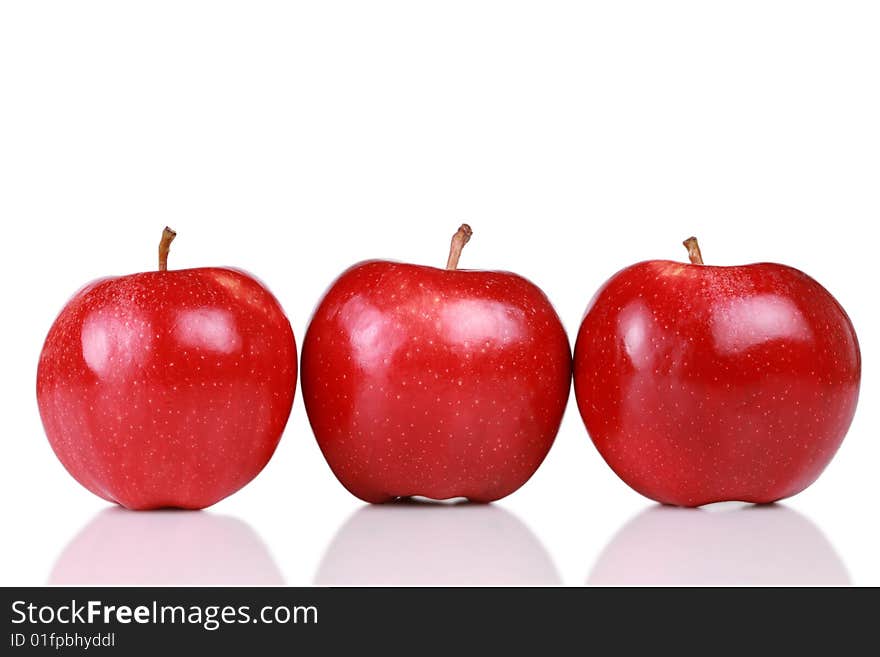 Three shiny red apples in a row isolated on white