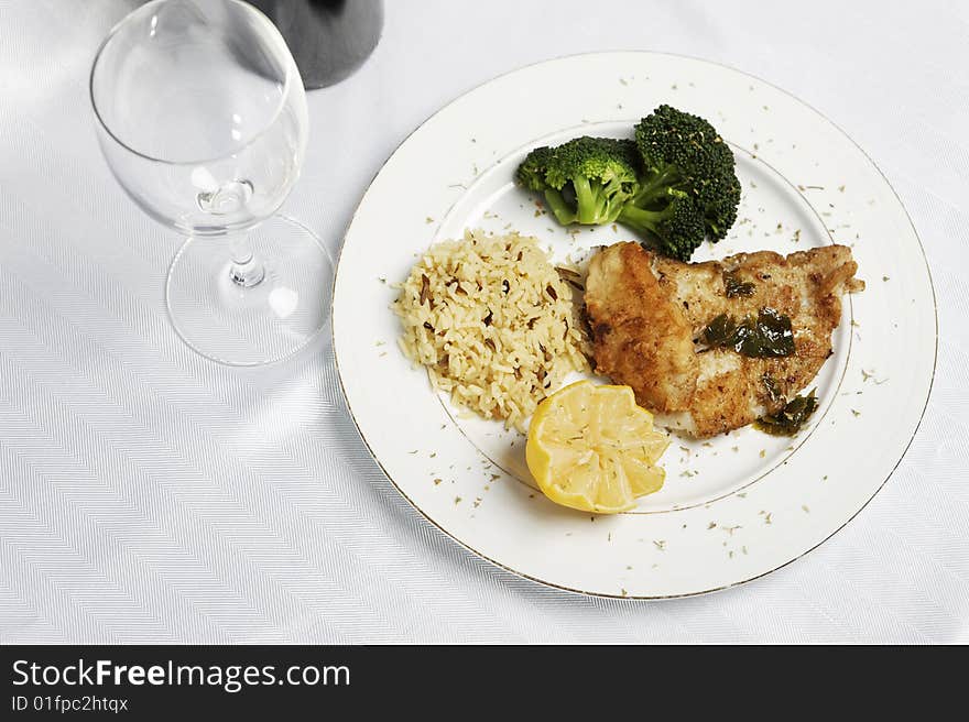 Fish meal with selective focus and wine bootle and glass in the background. Fish meal with selective focus and wine bootle and glass in the background