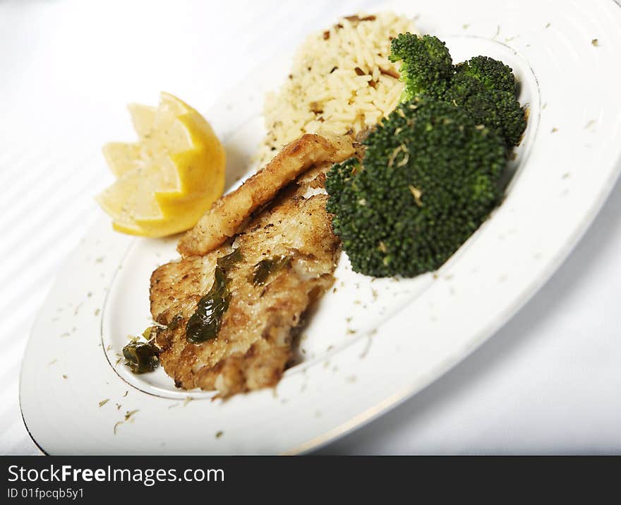 Fish meal with selective focus and wine bootle and glass in the background. Fish meal with selective focus and wine bootle and glass in the background