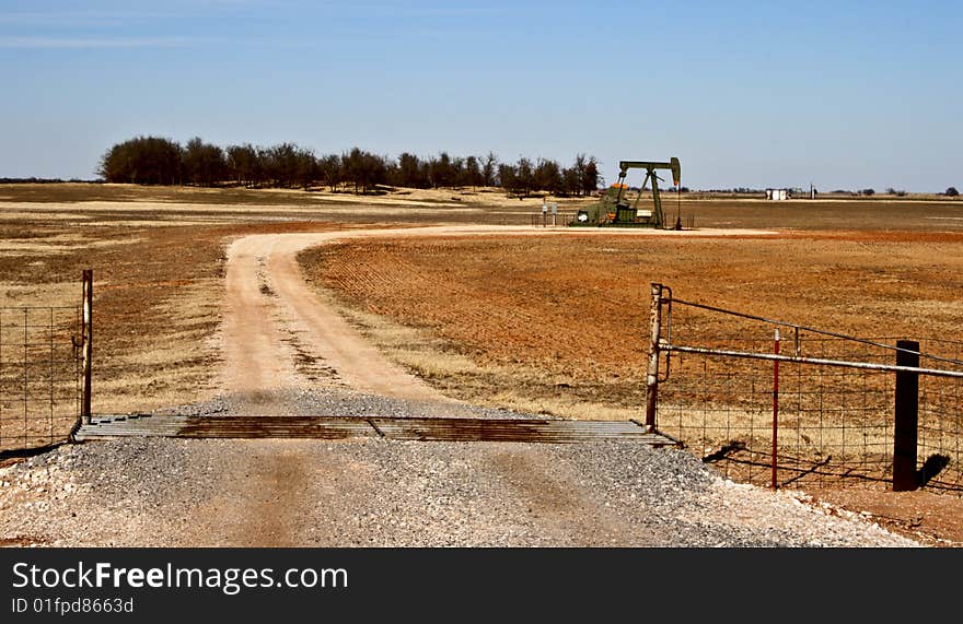 Dirt road leading up to an oil well. Dirt road leading up to an oil well