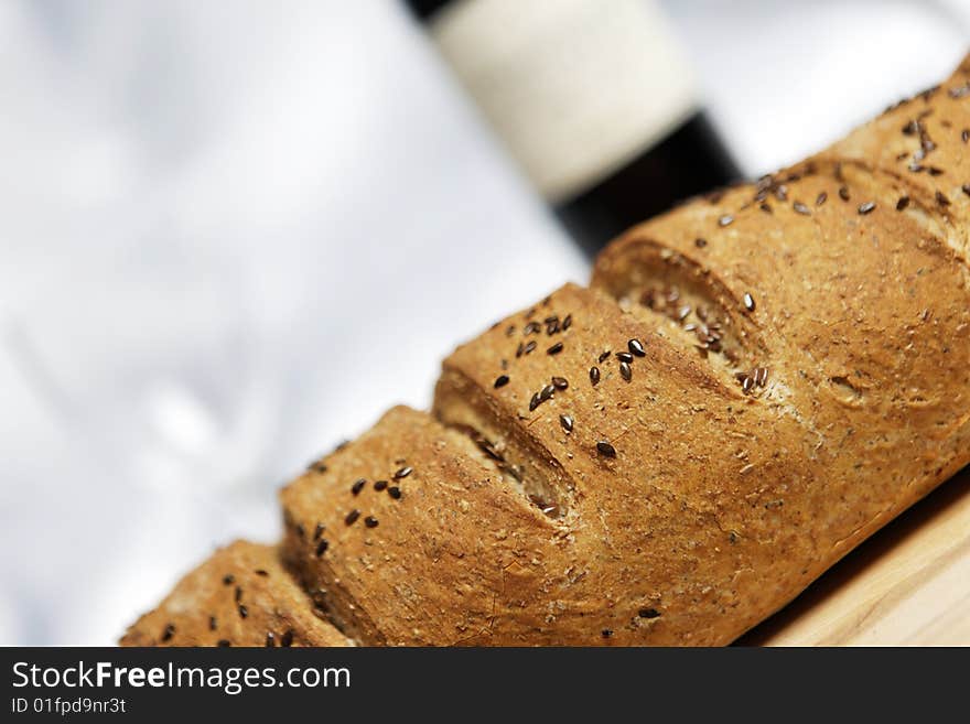 Fresh bread baked with soft backgrounf of wine and glass. Fresh bread baked with soft backgrounf of wine and glass