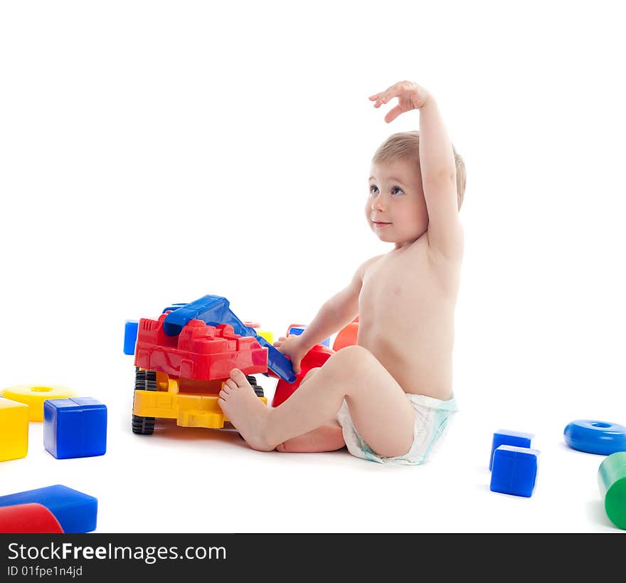 Little boy play with toys over white background with light shadows. Little boy play with toys over white background with light shadows.