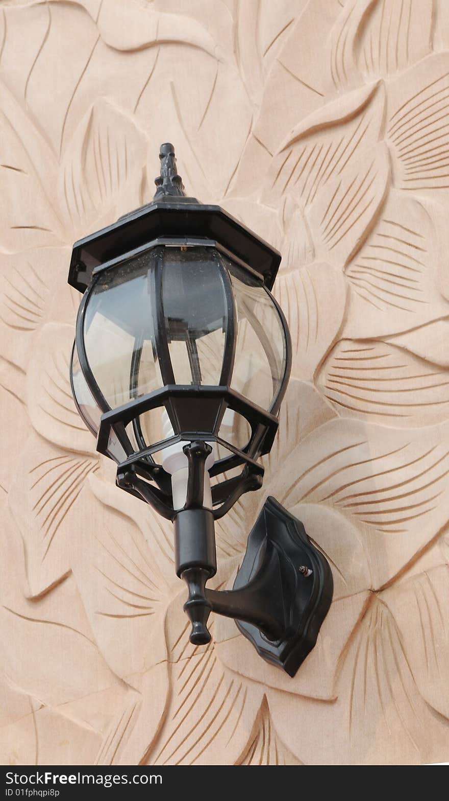 The electric lamp on the marble stone wall of classical pattern sculpture. The electric lamp on the marble stone wall of classical pattern sculpture.