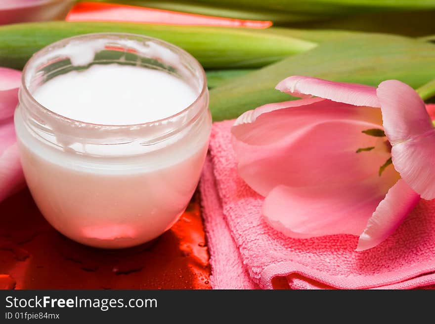 Cream, towel with flowers on red background