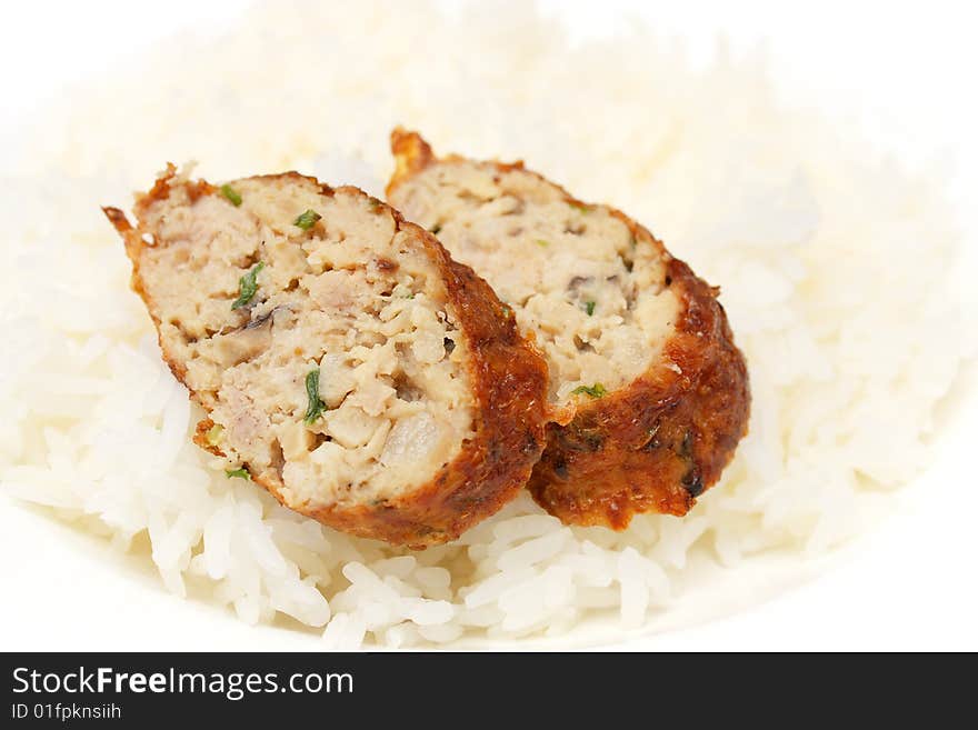 Chicken roll pieces put on white rice.