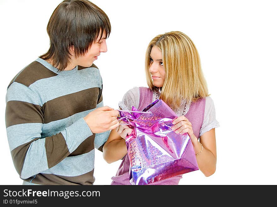 Young couple in incomprehension with gift packet on white. Young couple in incomprehension with gift packet on white