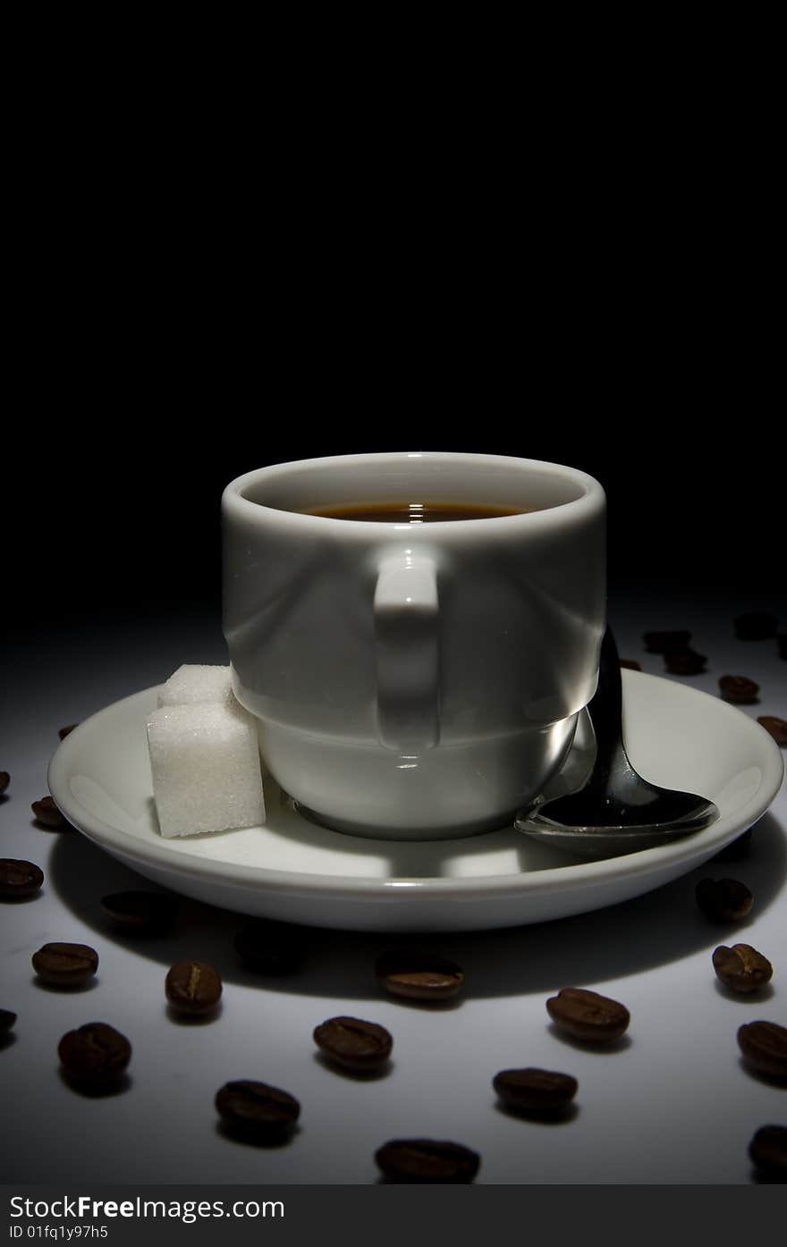 Coffe cup and lines of grains in the dark