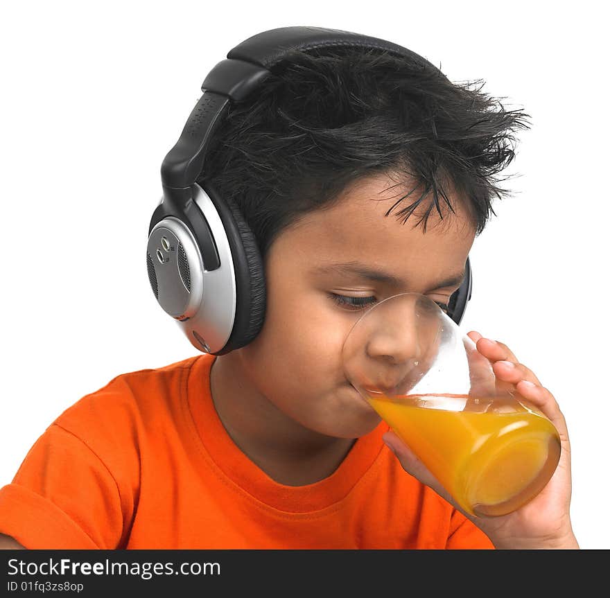 A cute asian boy drinking orange juice with his headphones on. A cute asian boy drinking orange juice with his headphones on